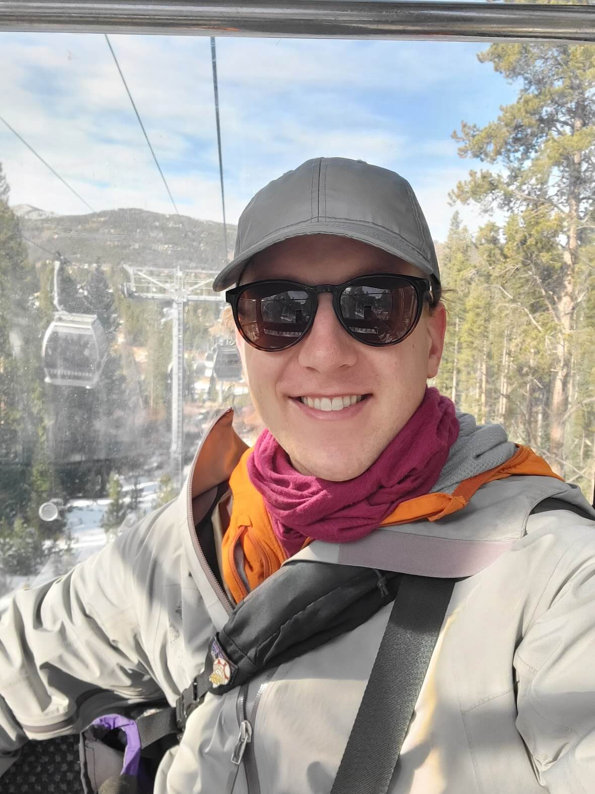 A headshot of Kris riding a gondola in the mountains